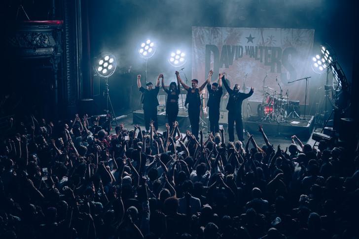 Les musiciens se tenant les mains (en l'air) debout face au public